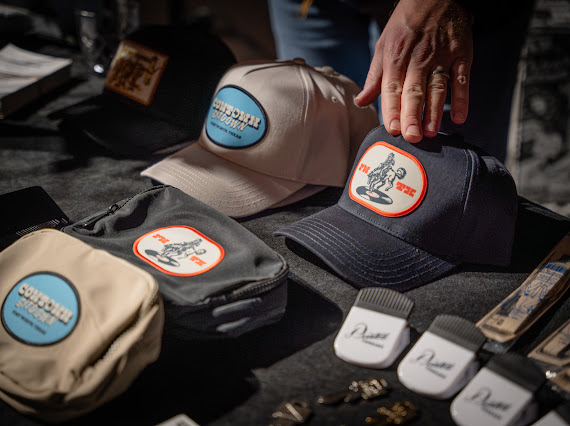 An assortment of patch hats and crossbody bags.